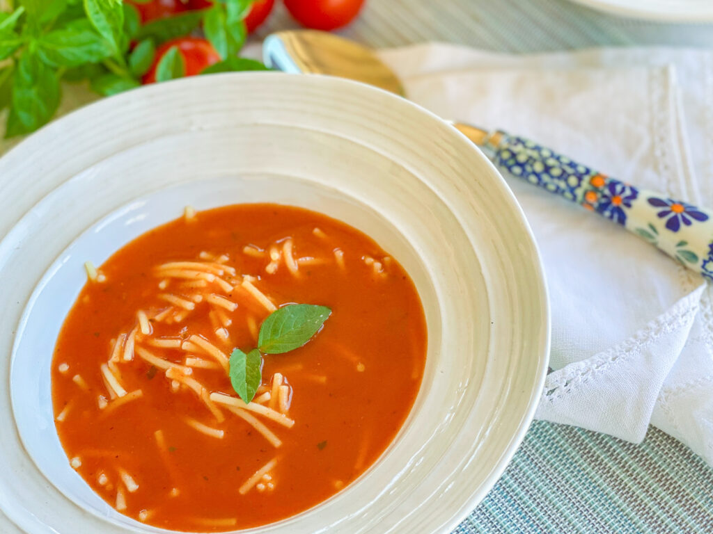 Polish tomato soup with noodles in a white bowl