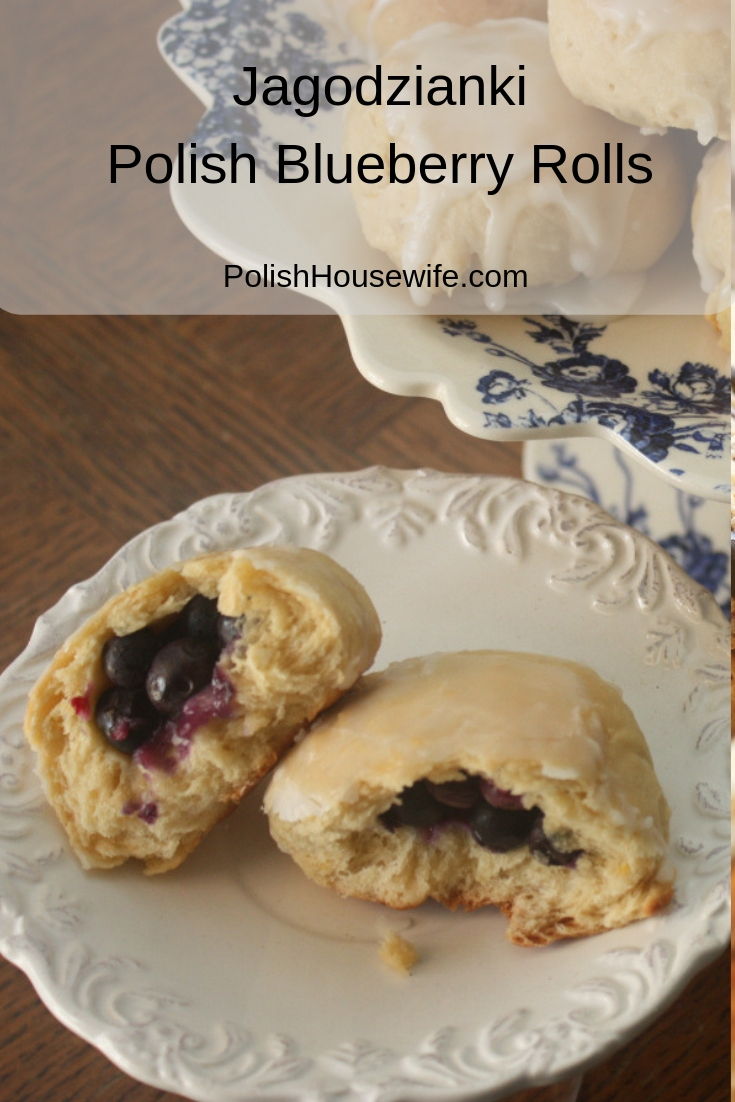 blueberry filled yeast rolls with glaze on a white saucer and a cake stand