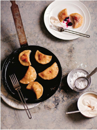 pierogi in a skillet with some on a plate