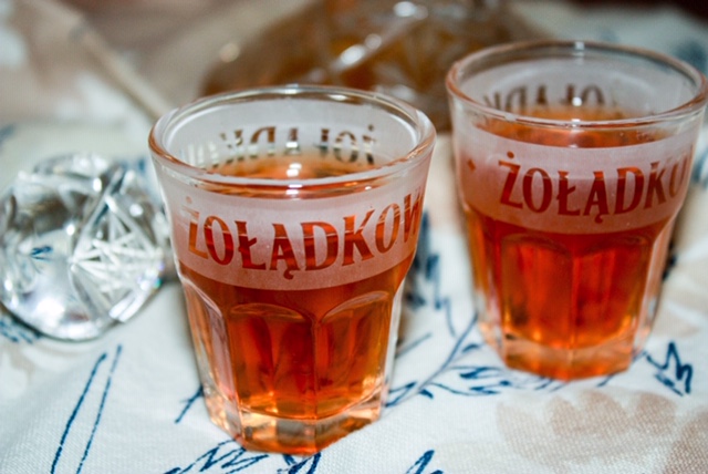 two shot glasses of zoladkowa gorzka on a patterned cloth with a small crystal decantor in the background