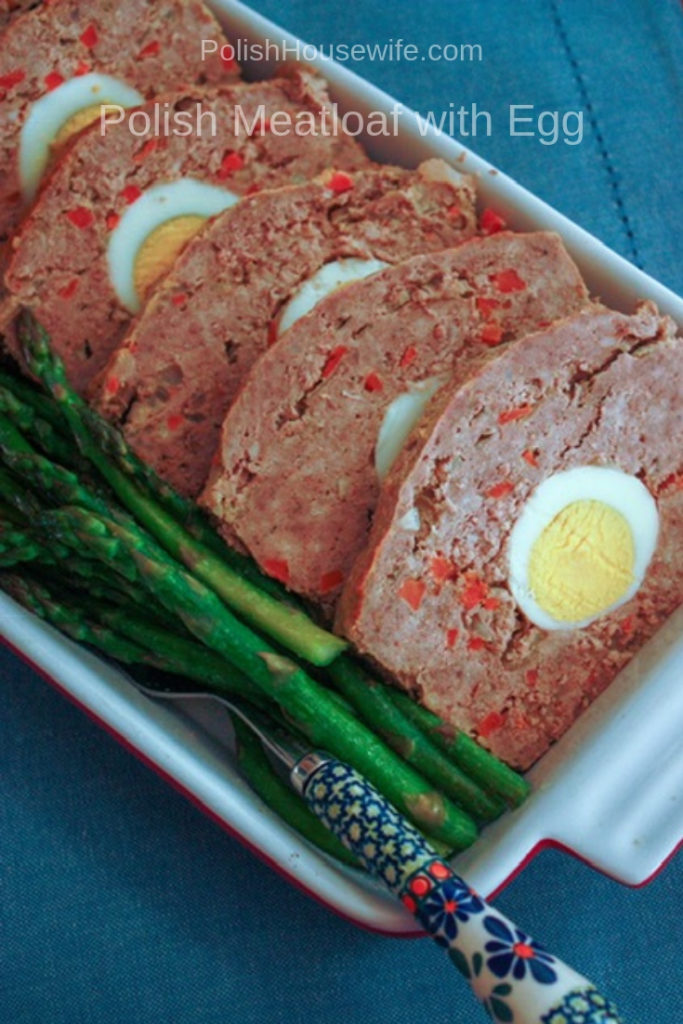 Slices of Polish meatloaf stuffed with hardboiled egg with asparagus alongside
