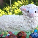 Easter lamb cake on green coconut with decorage eggs in foreground