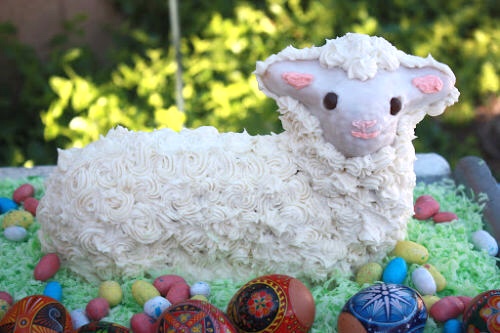 Easter lamb cake on green coconut with decorage eggs in foreground