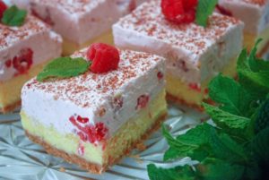 cheesecake topped with raspberry mousse garnished with raspberry and mint
