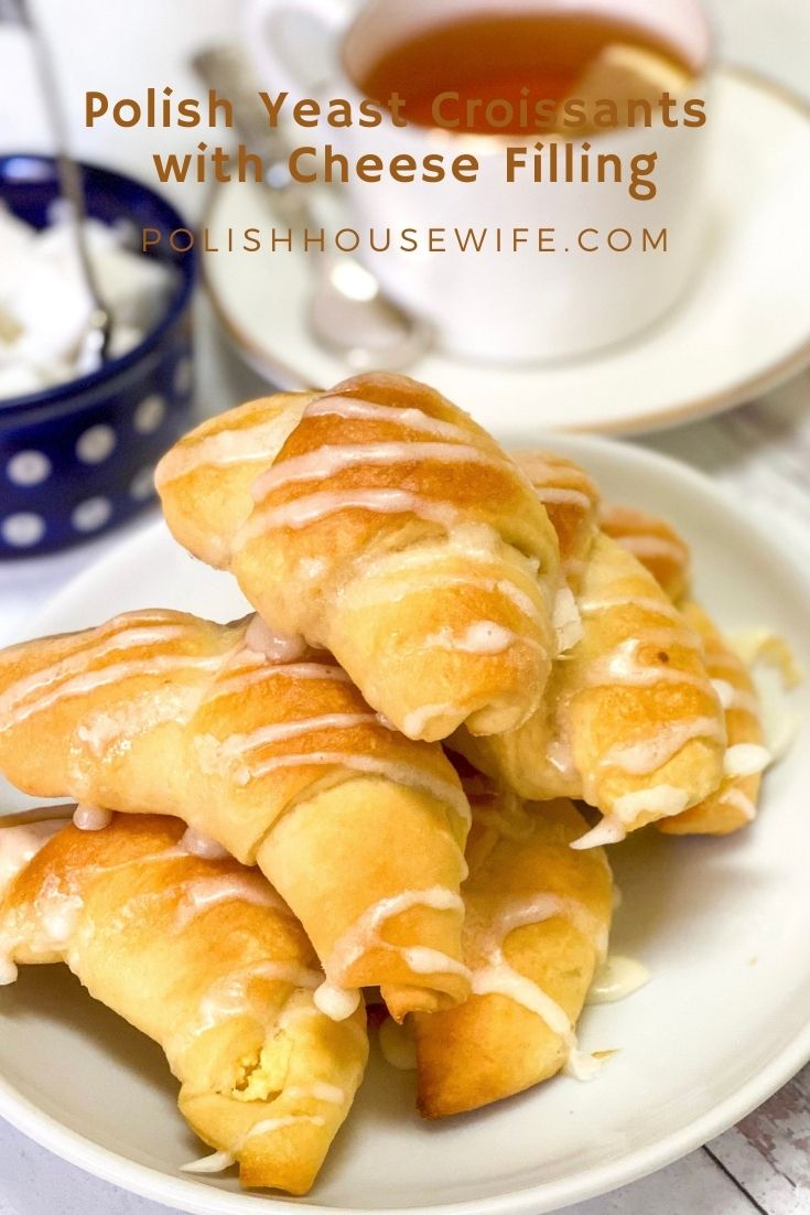 Polish yeast croissants with a cheese filling on a plate with a cup of tea. 